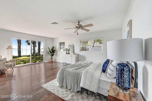 bedroom featuring multiple windows, wood finished floors, visible vents, and baseboards