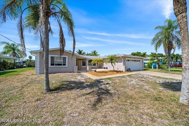 ranch-style home featuring a garage and a front lawn