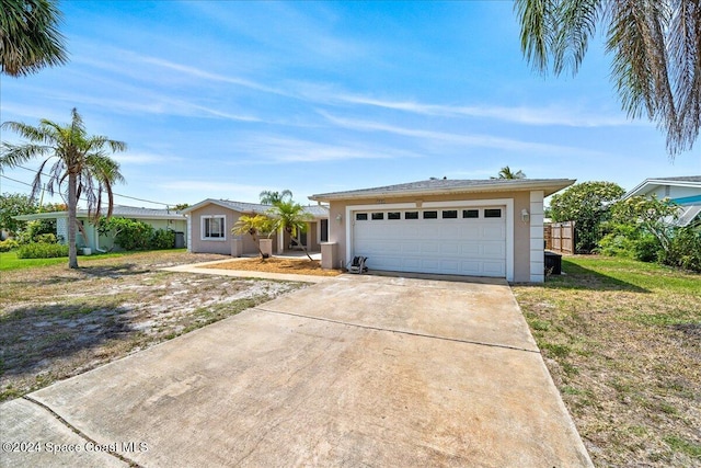 ranch-style house featuring a garage and a front lawn