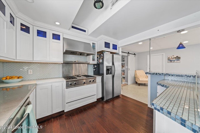 kitchen featuring white cabinetry, stainless steel appliances, a barn door, and wall chimney range hood