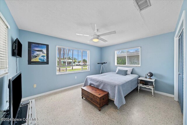 bedroom with ceiling fan, a textured ceiling, and a closet