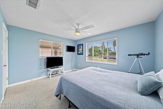 bedroom featuring multiple windows, a textured ceiling, and ceiling fan