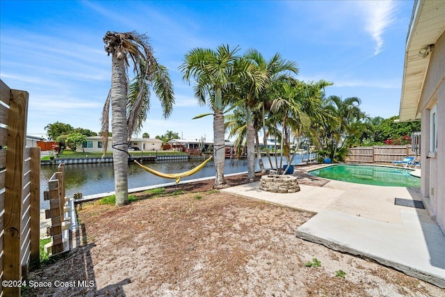 view of yard with a water view, an outdoor fire pit, and a patio