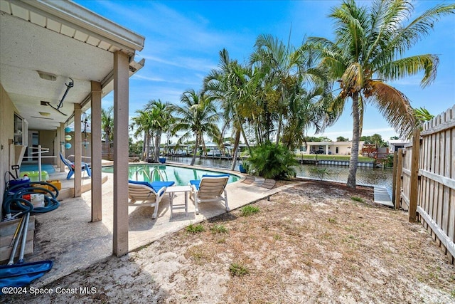 view of swimming pool with a water view and a patio area