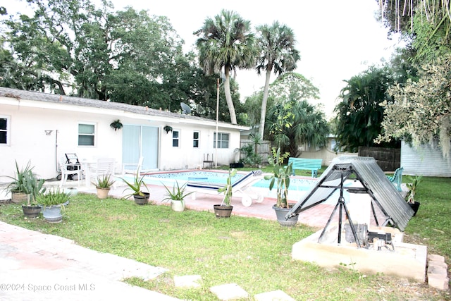 view of pool featuring a patio and a yard