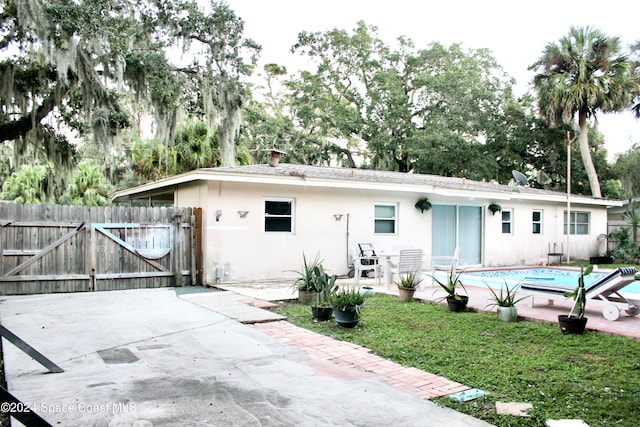 back of house featuring a fenced in pool and a patio area