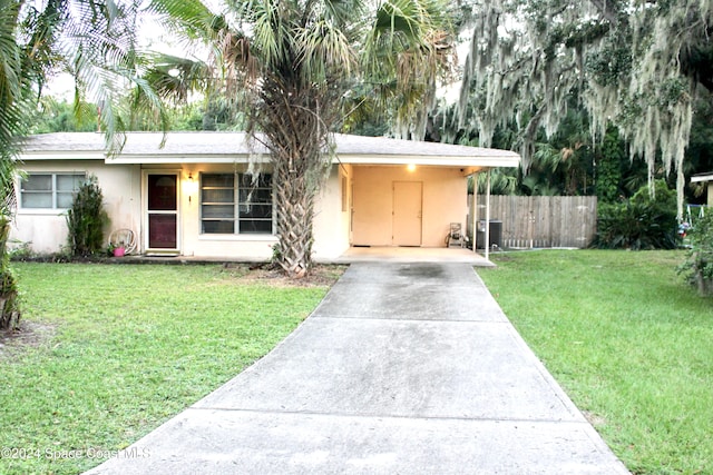 view of front facade featuring a front lawn, central AC, and a carport