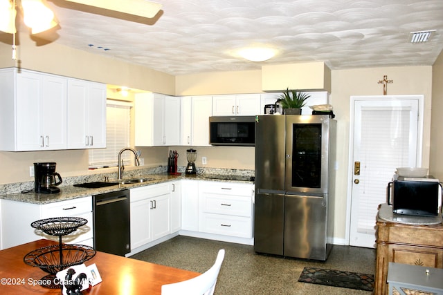 kitchen with stainless steel appliances, white cabinets, sink, ceiling fan, and light stone countertops