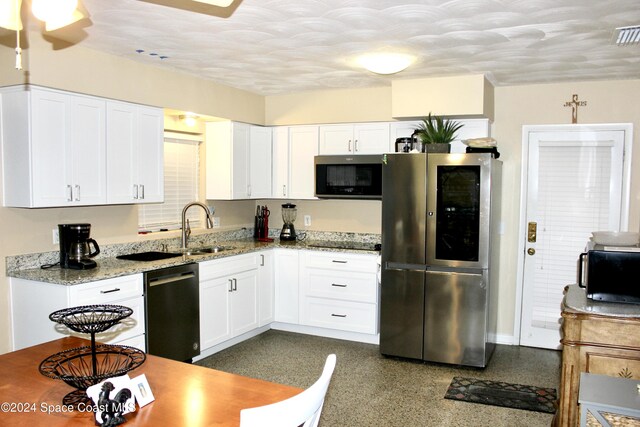 139 W Laila Dr W, Melbourne, FL 32904 - kitchen featuring black appliances, white cabinets, light stone countertops, and a sink