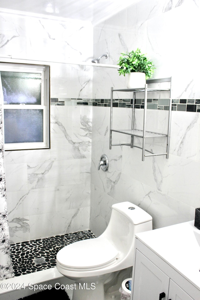 bathroom with toilet, vanity, curtained shower, and tile walls