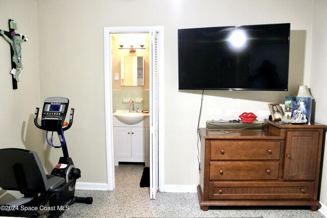 139 W Laila Dr W, Melbourne, FL 32904 - bedroom with a sink, baseboards, dark aggregate flooring, and connected bathroom