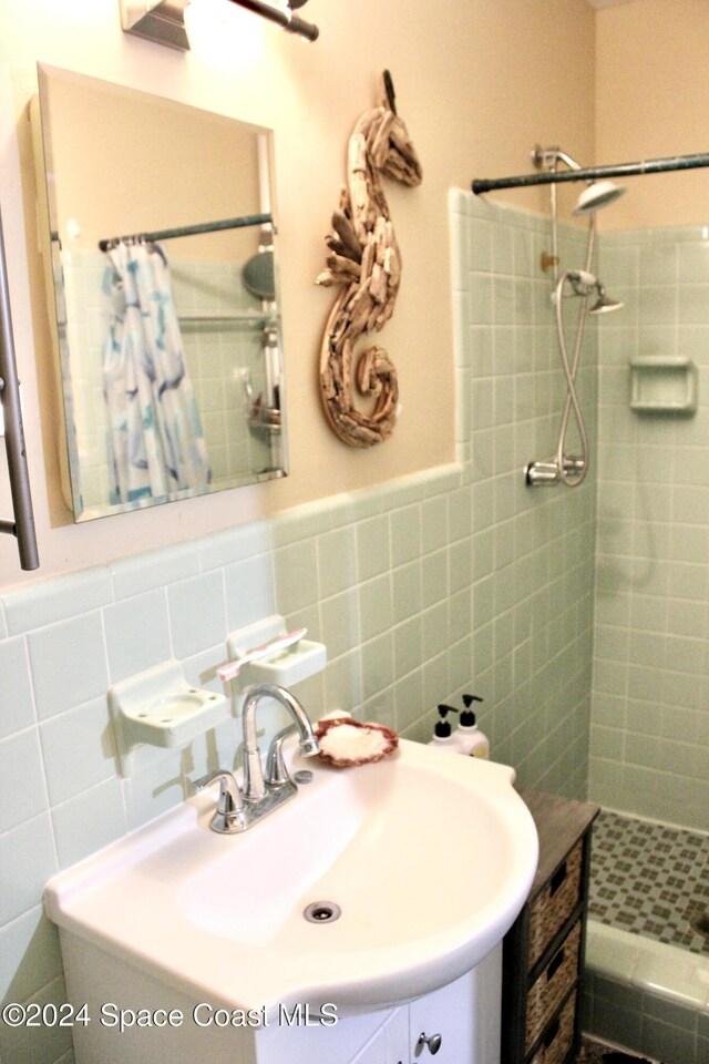 139 W Laila Dr W, Melbourne, FL 32904 - bathroom with tiled shower, vanity, tile walls, and wainscoting