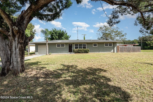 ranch-style house featuring a garage and a front lawn