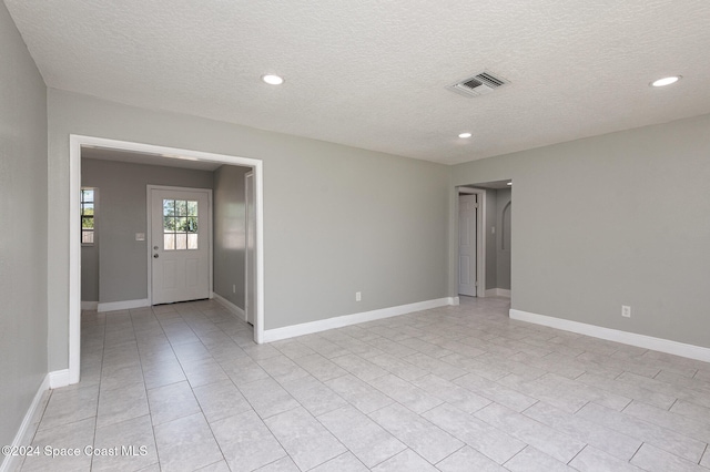 spare room with a textured ceiling