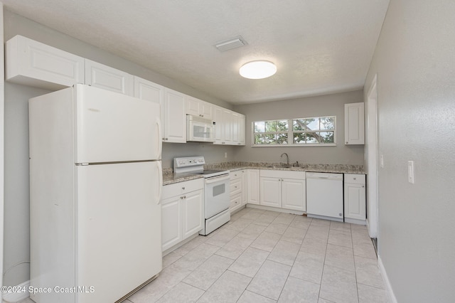 kitchen featuring white cabinets, a textured ceiling, sink, light tile patterned flooring, and white appliances