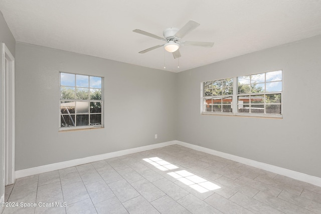 tiled spare room with ceiling fan