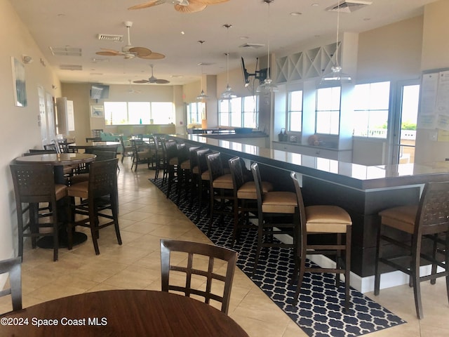 bar with pendant lighting, light tile patterned flooring, and ceiling fan