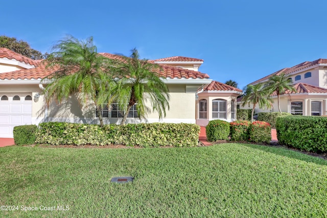 mediterranean / spanish house featuring a front lawn