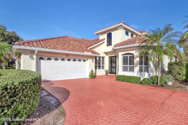 mediterranean / spanish home with a garage