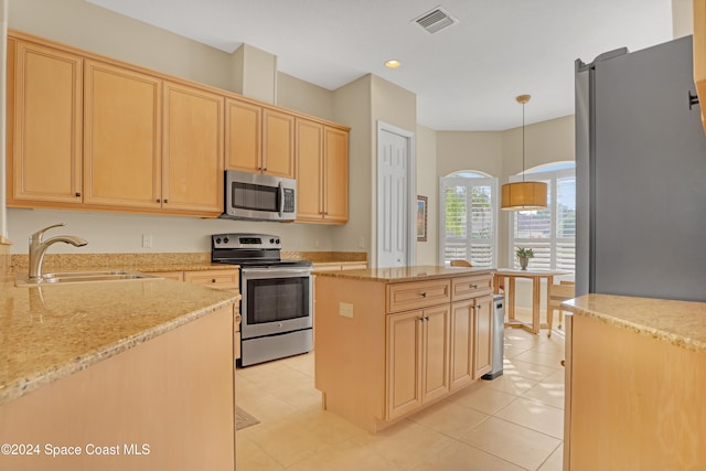 kitchen with stainless steel appliances, a center island, light stone counters, sink, and decorative light fixtures