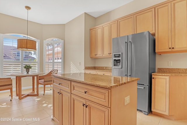 kitchen with light tile patterned flooring, a center island, decorative light fixtures, and stainless steel fridge