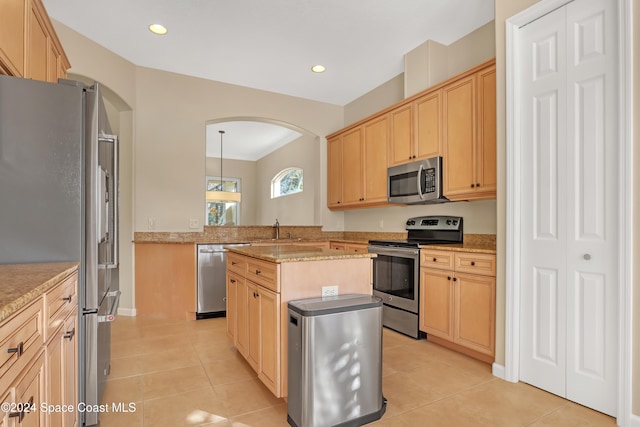 kitchen featuring sink, appliances with stainless steel finishes, light brown cabinets, light tile patterned floors, and decorative light fixtures