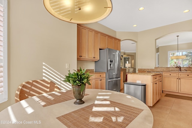 kitchen with hanging light fixtures, light brown cabinetry, sink, and high end fridge