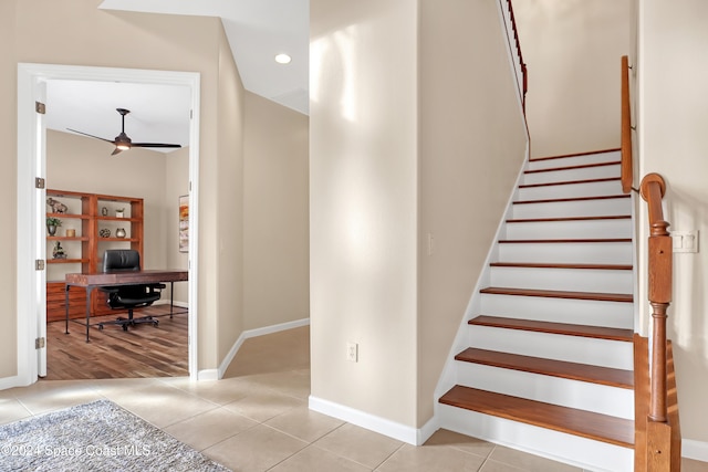 stairs with ceiling fan and tile patterned floors