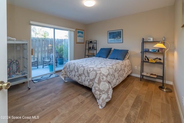 bedroom with hardwood / wood-style floors and access to exterior