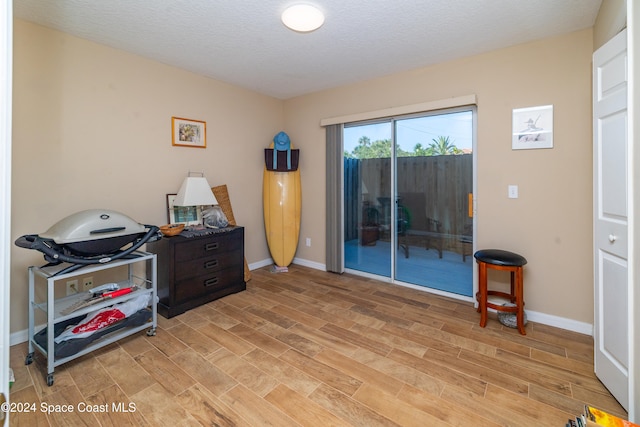 miscellaneous room with light hardwood / wood-style flooring and a textured ceiling