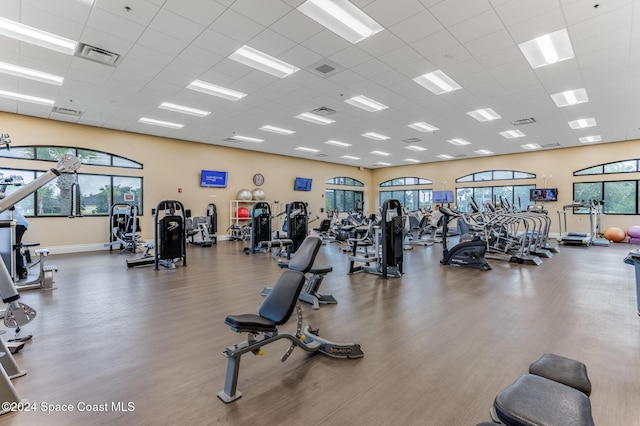 workout area with dark wood-type flooring and a drop ceiling