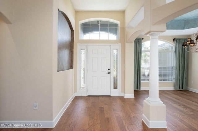 entrance foyer featuring dark hardwood / wood-style flooring and decorative columns