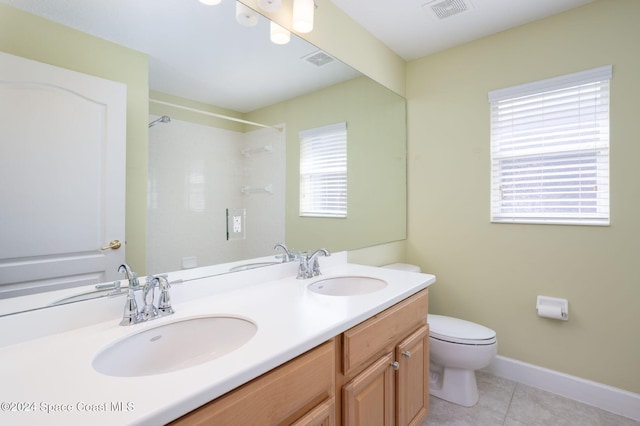 bathroom featuring tile patterned flooring, vanity, toilet, and a shower