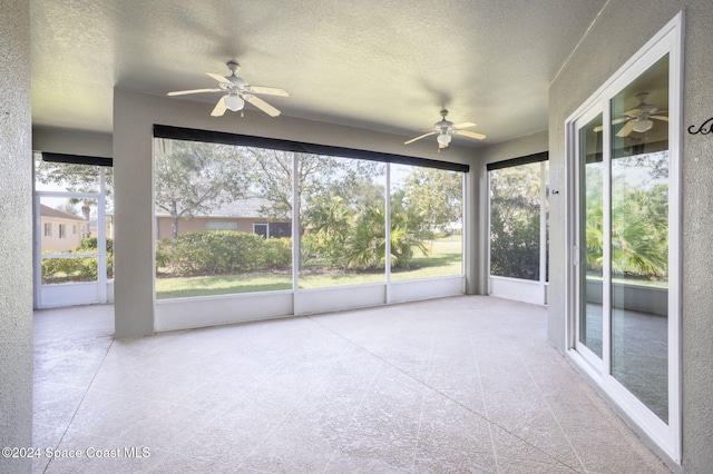 unfurnished sunroom featuring a wealth of natural light and ceiling fan