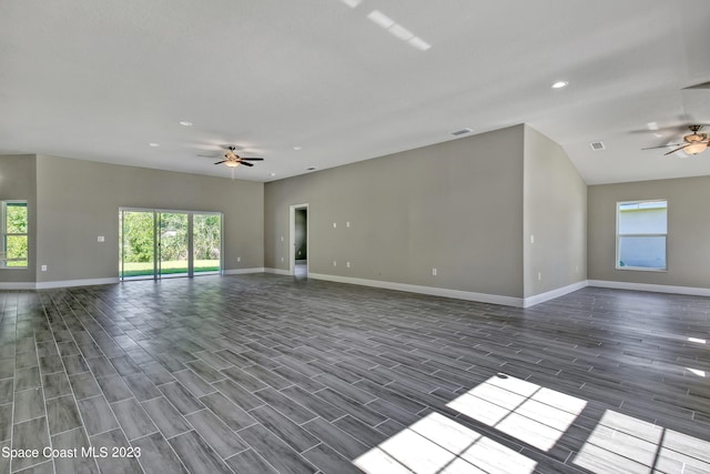 empty room featuring ceiling fan, a wealth of natural light, and dark hardwood / wood-style floors