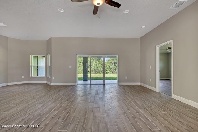 empty room featuring a textured ceiling, light hardwood / wood-style flooring, and ceiling fan