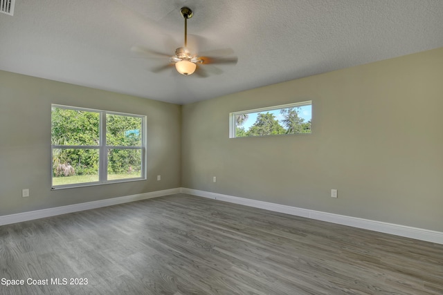 spare room with ceiling fan, wood-type flooring, and a textured ceiling