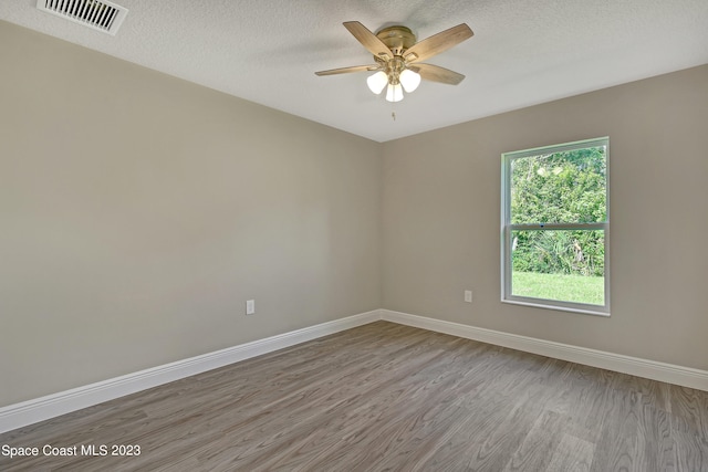 empty room featuring hardwood / wood-style floors, ceiling fan, and a textured ceiling