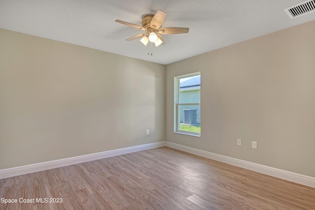 unfurnished room with a textured ceiling, light hardwood / wood-style floors, and ceiling fan