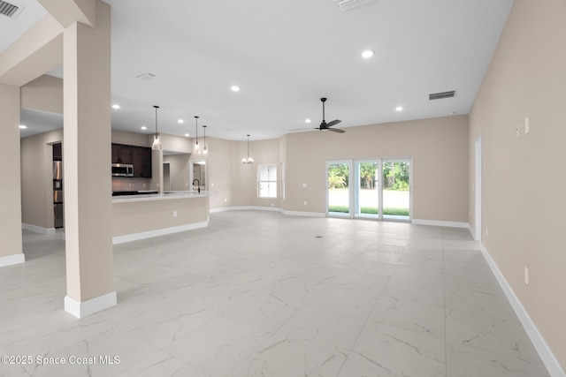 unfurnished living room with ceiling fan and sink