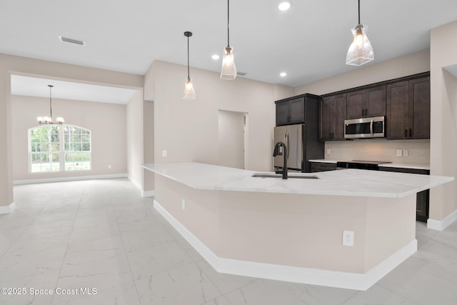 kitchen featuring hanging light fixtures, tasteful backsplash, appliances with stainless steel finishes, and a spacious island