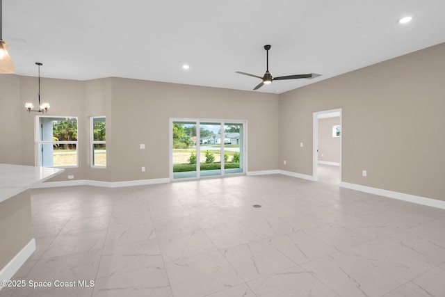 unfurnished living room featuring ceiling fan with notable chandelier