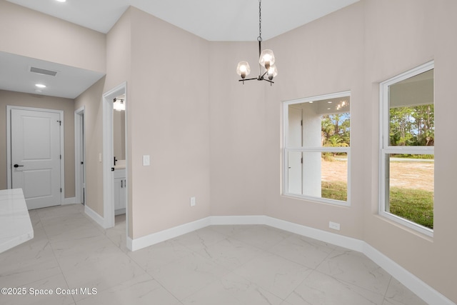 unfurnished dining area with a notable chandelier