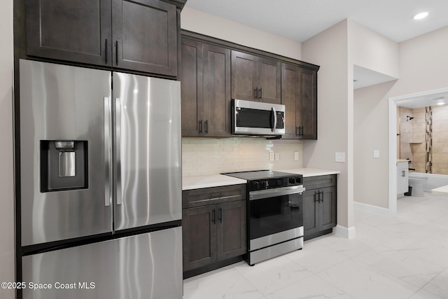 kitchen with dark brown cabinetry, backsplash, and appliances with stainless steel finishes