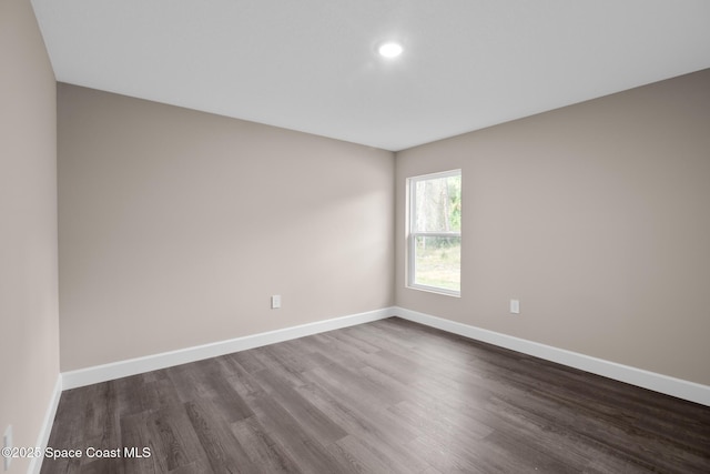 spare room with dark wood-type flooring