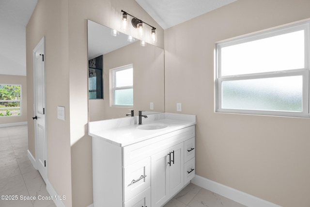 bathroom with lofted ceiling, vanity, and a wealth of natural light