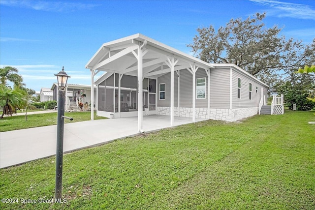 rear view of property featuring a sunroom and a yard