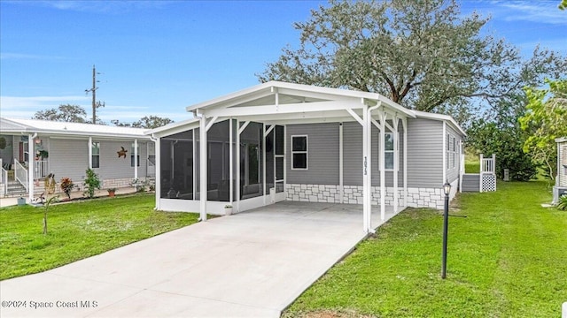 view of front of home featuring a sunroom, a carport, and a front lawn