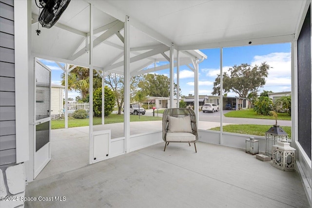 unfurnished sunroom featuring lofted ceiling and plenty of natural light