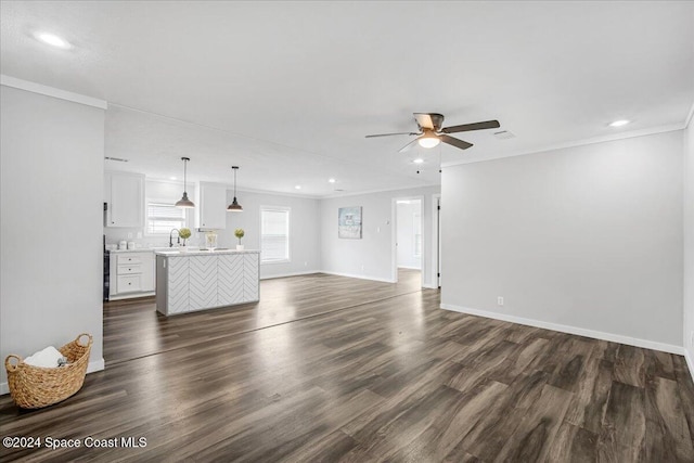 unfurnished living room featuring ceiling fan, dark hardwood / wood-style floors, sink, and ornamental molding